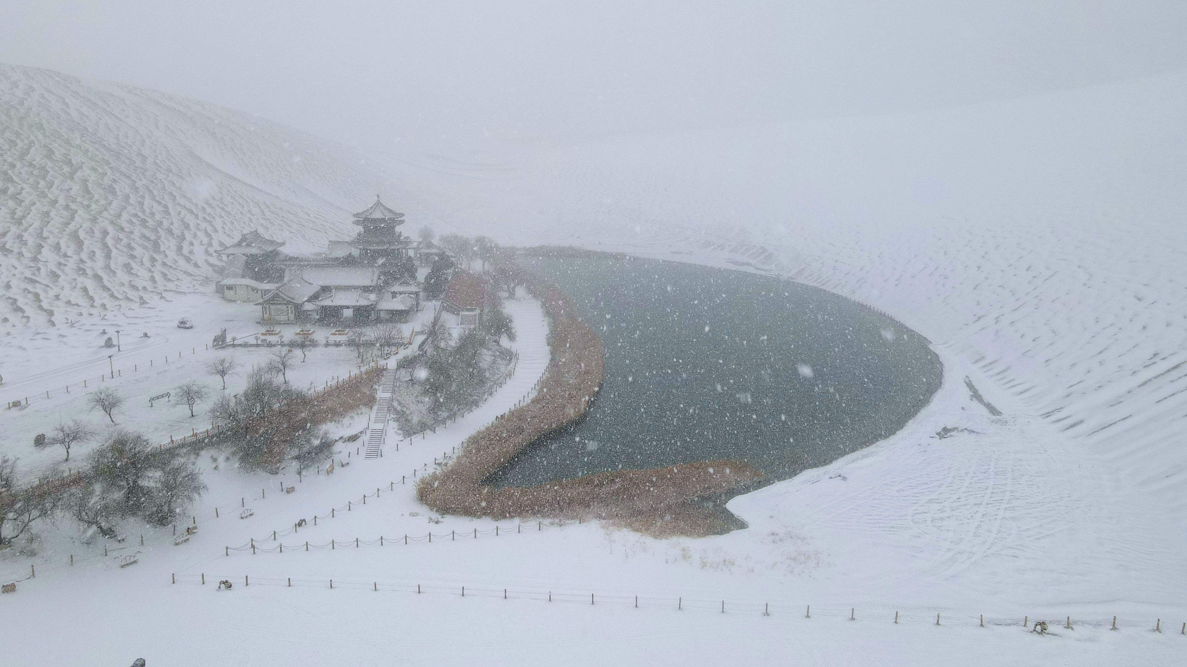 2022年11月27日拍攝的甘肅省敦煌市鳴沙山月牙泉景區(qū)雪景（無人機照片）。張曉亮攝