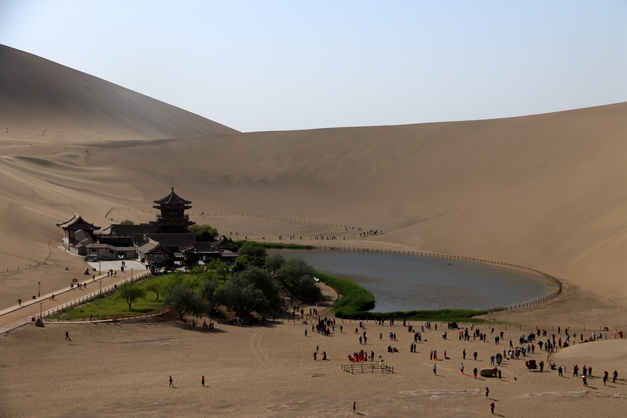 2023年5月11日，游客在甘肅省敦煌市鳴沙山月牙泉景區(qū)游覽。張曉亮攝