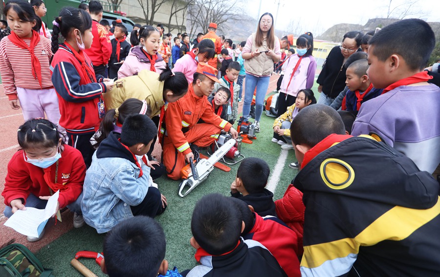 森林消防隊員在七里河區(qū)二十里鋪鎮(zhèn)中心小學向師生展示滅火裝備。裴海博攝