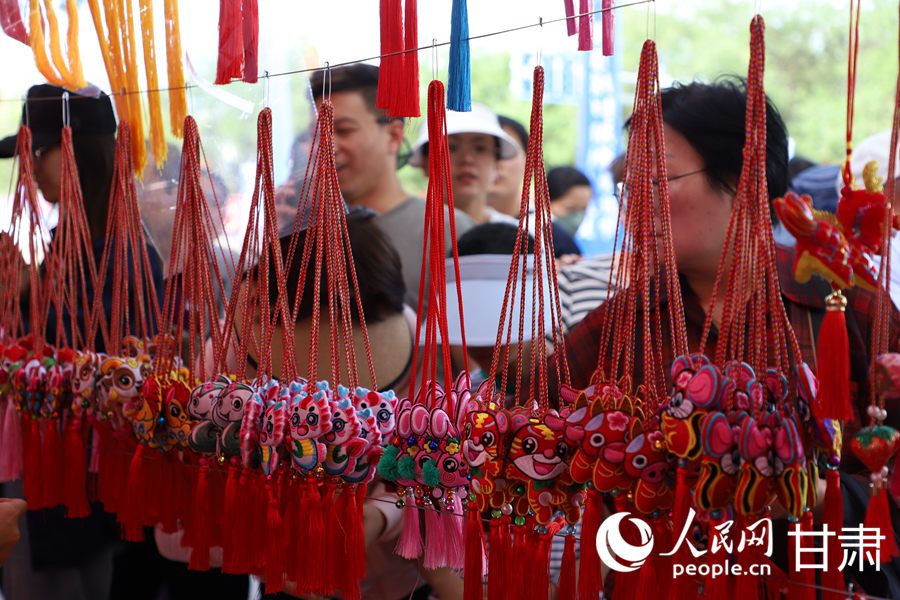 在慶陽民俗文化普品展銷區(qū)，色彩艷麗、做工精湛的香包吸引了眾多市民游客駐足。人民網(wǎng)記者 邵蘭攝